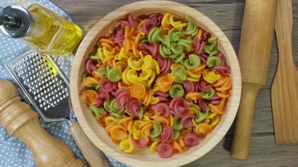 Multicolored Pasta Rotating in Slow Motion Top View. Rotation of Colored Spiral Pasta . Heap of