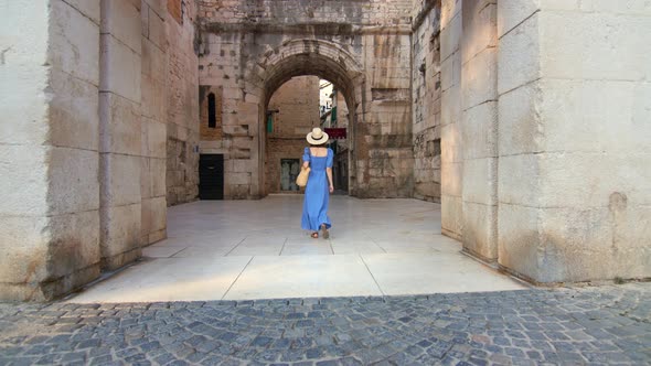 Young girl in a blue dress walking on the street in the city. Split, Croatia