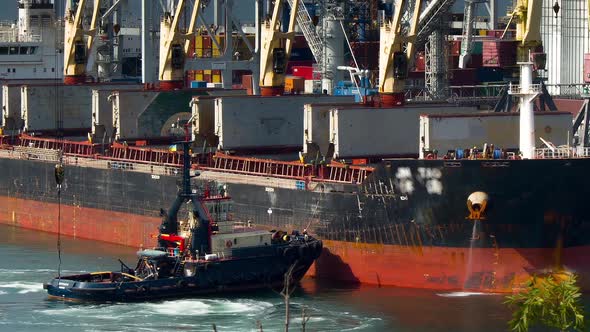 Tug Boat Approaching To Assist Cargo Ship