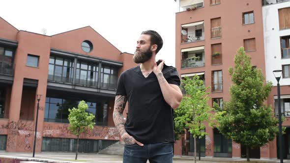 young beautiful bearded man posing outdoor looking away