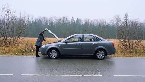 A Young Woman a Broken Car and Opens the Hood