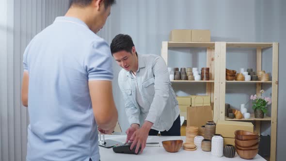 Close up hands of young man customer use credit card pay for vase goods order.