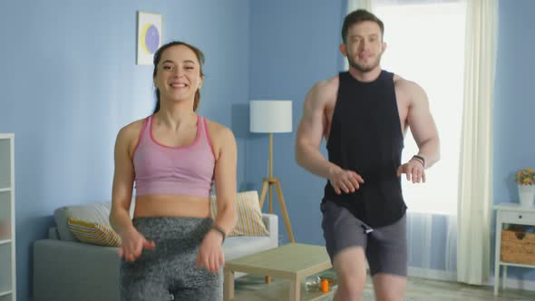 Young Man and Woman Practice Cardio Workout at Home