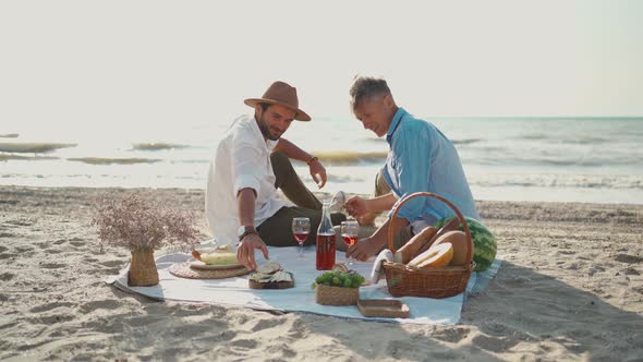 Lgbt Gay Couple Having Romantic Picnic at the Beach Holding Hand Each Other Sitting on Blanket with