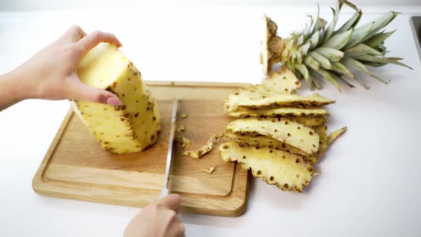 Hands slicing pineapple. Hands of woman peeling pineapple with knife