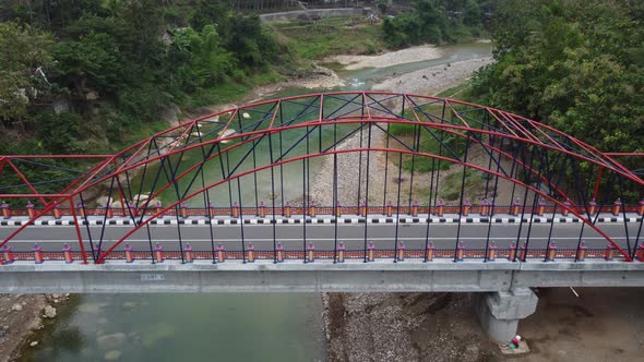 Beautiful aerial view of a bridge over a river nestled between mountains