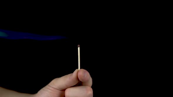 A Man Lights a Match From the Fire. A Man Holds a Match in His Hand and Lights It on a Black