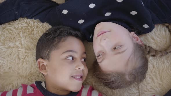 Cute African American Boy and Blond Caucasian Girl Lying on the Floor