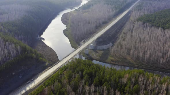 An Aerial View of a Road Bridge Over a River in the Forest.