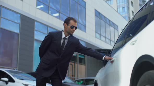 Bodyguard in Suit Looking Around and Opening Car Door to Female Boss Service