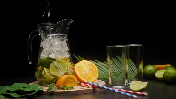 Making Citrus Fruit Drink in Jug Pouring Carbonated Water Shooting of Cocktail of Orange Lemon and