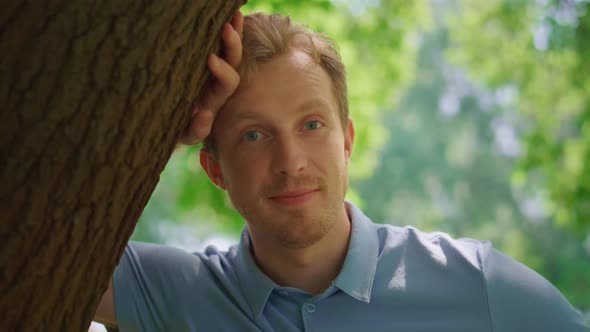 Portrait of Man Lean on Tree in Park Closeup