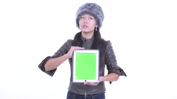 Happy Beautiful Asian Woman Thinking While Showing Digital Tablet