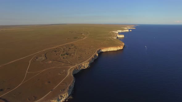 Drone View of the Coastline with Sheer White Rocks at Sunset