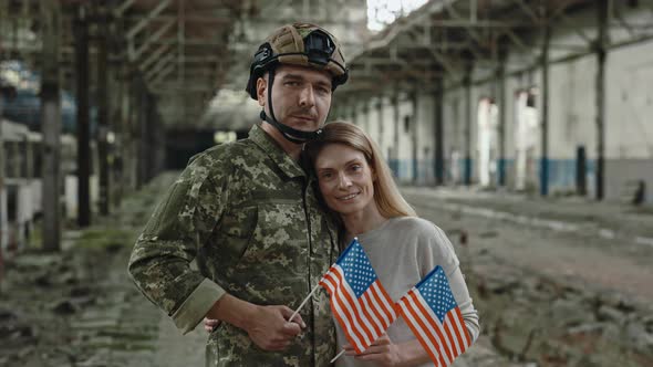 Portrait of Warrior with Wife Holding American Flag on Plant