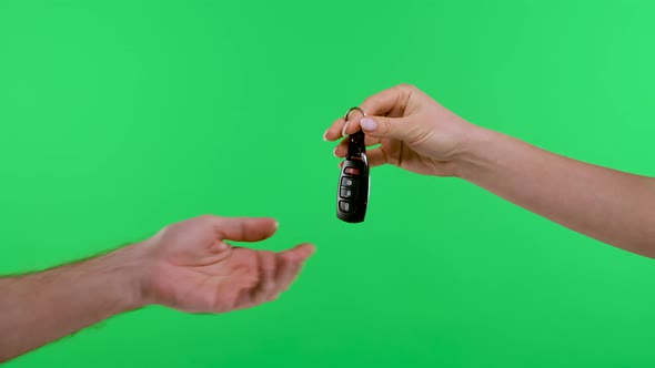 A Woman's Hand Holding a Car Remote Puts the Car Keys in the Man's Palm