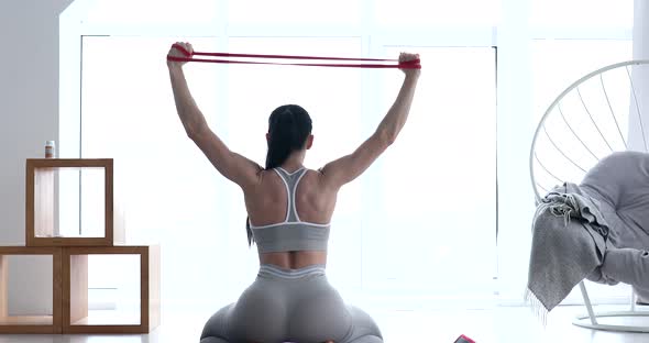 Woman doing exercises with resistance bands at home.