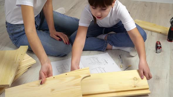 Happy Family Mother and Daughter Assembling Wooden Furniture Together