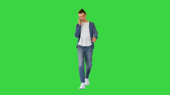 Young White Man Walks Talking on His Smartphone and Smiling on a Green Screen Chroma Key