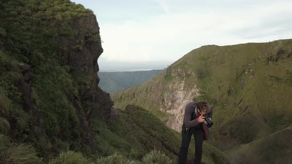 Photographer Traveler Photographs the Landscape on the Edge of the Mountain