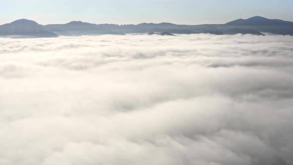 Aerial Flight Beyond Sky Over Morning Fluffy Clouds High in the Mountains