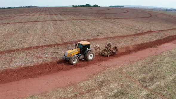 Aerial low shot of a tractor harvesting in circles in Brazil.