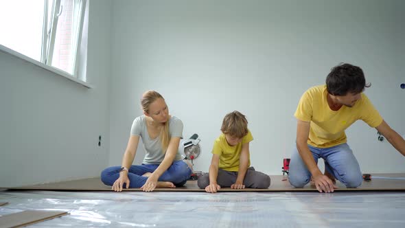 A Family of Mother Father and Son Install Laminate on the Floor in Their Apartment