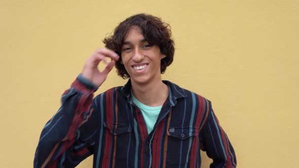 Happy young Latin teenager smiling in front of camera