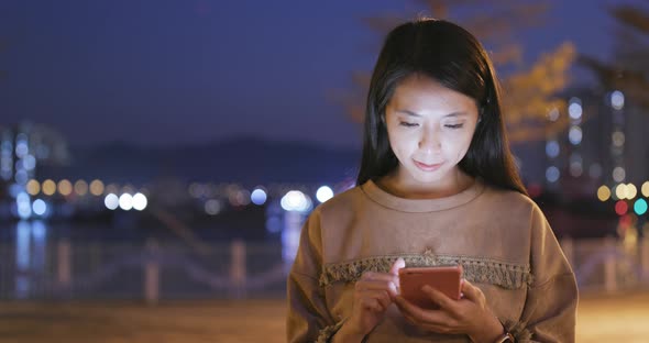 Asian Woman use of smart phone in city at night