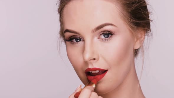 Female Doing Make-up on Grey Background