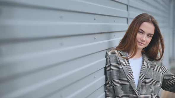 Portrait of a Young Girl in a Blazer By a Wall on the Street