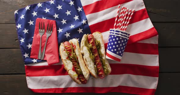 Video of hot dogs with mustard and ketchup over flag of usa on a wooden surface