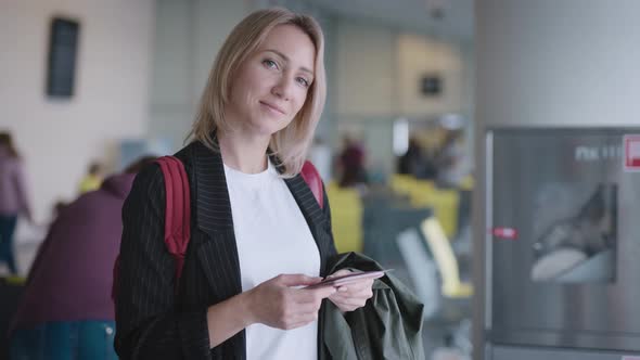 An Attractive Young Woman at the Airport is Waiting for Her Departure