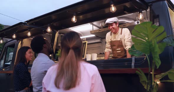 Multiracial people ordering gourmet meal in front of food truck outdoor