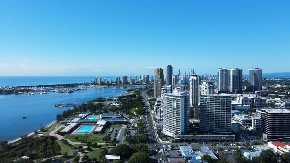 Towering high-rises and aquatic centre built on the foreshore of a coastal town. Revealing drone vie