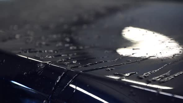 Close Up on Water Drops on Reflective Painted Surface of a Car