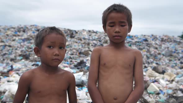 Poor Children Standing With Garbage Dump