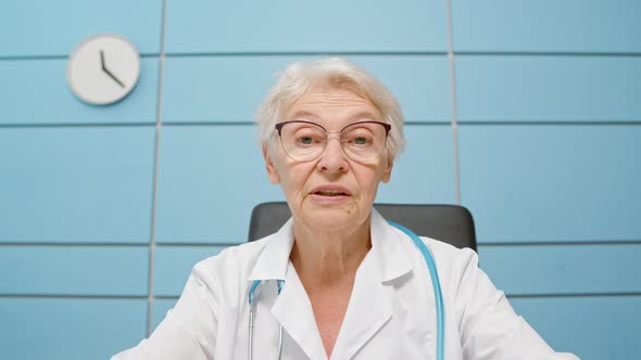 Senior female doctor in robe with elegant glasses