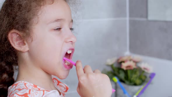 Portrait Happy Cute Young Teenage Girl Brushing Teethin the Morning in Bathroom and Smiling