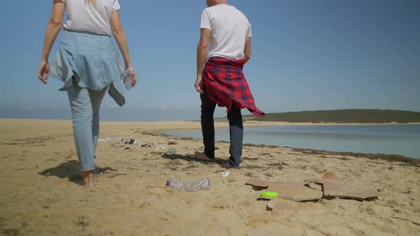 Couple Walking on Beach Full of Garbage