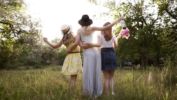 Rare View of a Group of Three Young Nice Girls Embrace Themselves Looking at Perspective