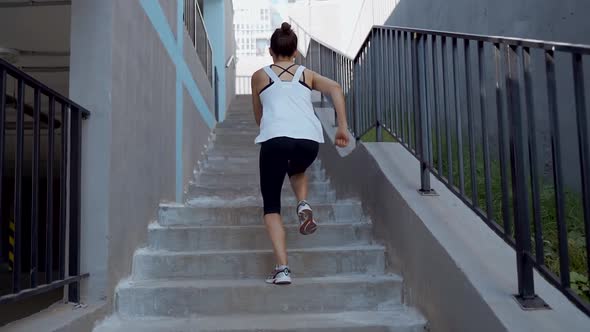 Girl athlete runs up the stairs.