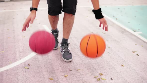 Unrecognizable Man Practicing Basketball on the Street Court