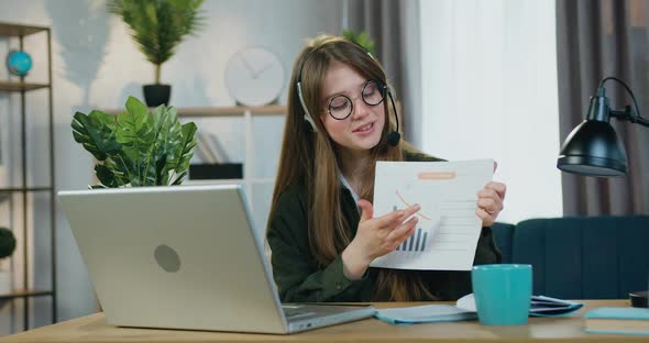 Female Freelancer in Headset which Sitting in front of Laptop During Video conference