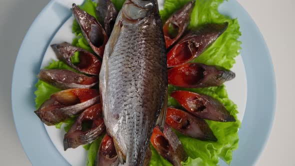 Delicacy Delicious Juicy Fresh Fish with Caviar on Lettuce Leaves Spinning on a Background