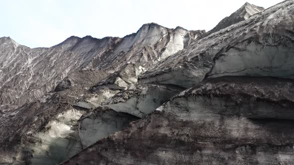 Pull up shot of a Glacier in Iceland, Sunny Day and the Ice is covered by Ash