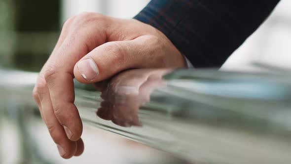 Man Taps Fingers on Metal Railing on City Street Close View