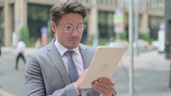 Businessman Browsing Internet on Tablet, Outdoor