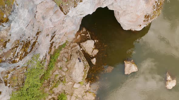 A man is standing on the top rock Tourist in the mountains Mountain gorge