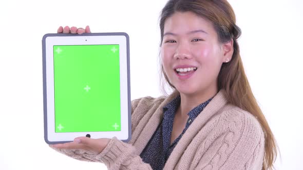 Face of Happy Young Asian Woman Showing Digital Tablet Ready for Winter